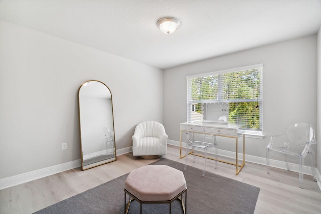 sitting room with baseboards and wood finished floors