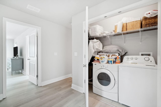 laundry area with visible vents, baseboards, laundry area, light wood-style flooring, and separate washer and dryer