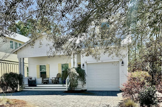 view of front of house with a garage, a porch, and driveway