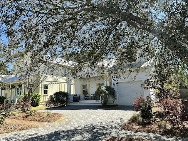 obstructed view of property with an attached garage and decorative driveway