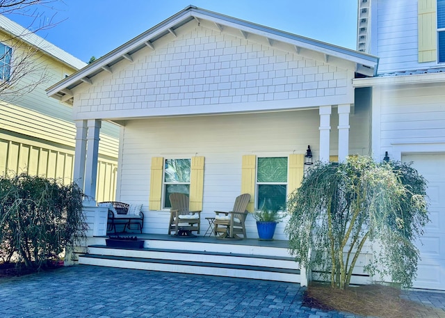 back of house with a porch and a garage