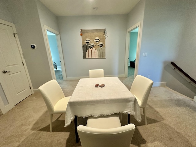 dining room with light carpet and baseboards