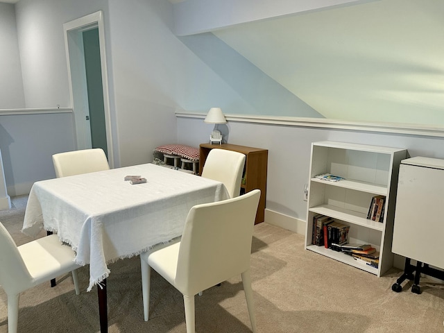 dining space with vaulted ceiling and carpet floors