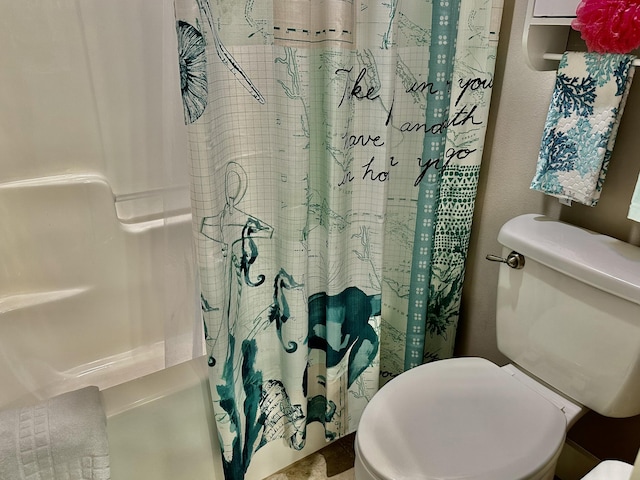 bathroom featuring a shower with shower curtain and toilet