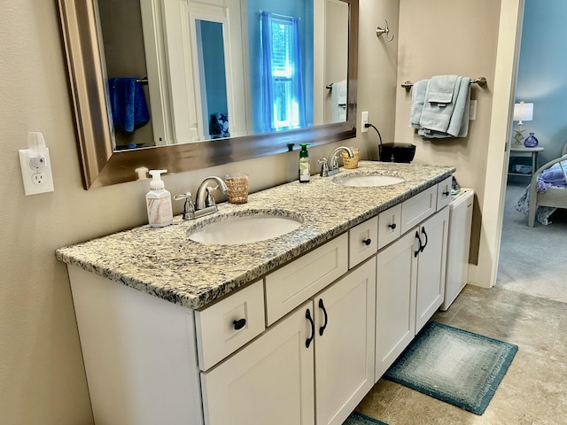 ensuite bathroom featuring a sink, baseboards, double vanity, and ensuite bathroom