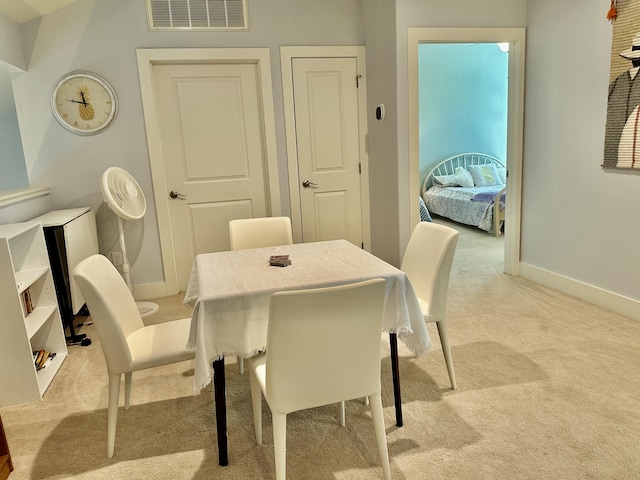 dining space featuring visible vents, baseboards, and light colored carpet