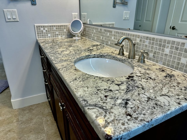 bathroom with tasteful backsplash, vanity, and baseboards