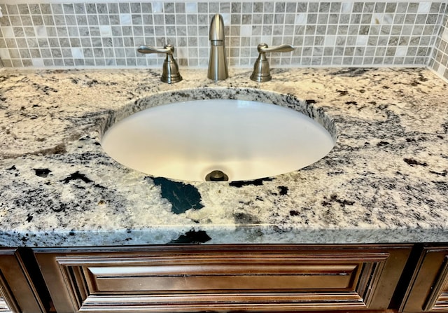 interior details featuring a sink and tasteful backsplash