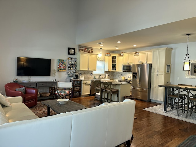 living area featuring recessed lighting, dark wood finished floors, and a towering ceiling