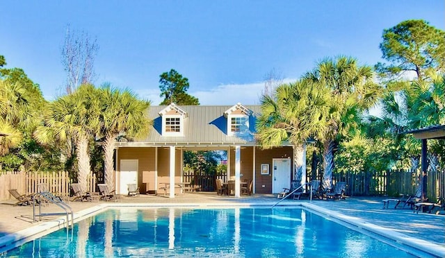 community pool with a patio area and fence