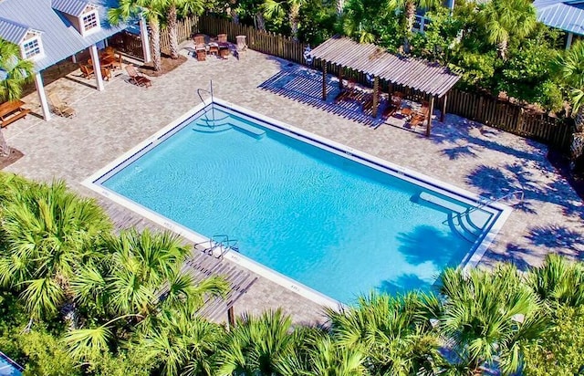 community pool featuring a patio, an outdoor fire pit, and a fenced backyard