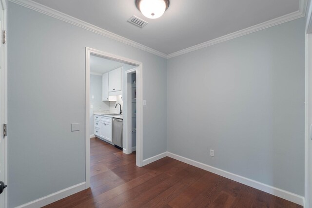 spare room with visible vents, baseboards, dark wood-style floors, and crown molding