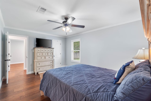 bedroom with visible vents, dark wood-type flooring, baseboards, and ornamental molding