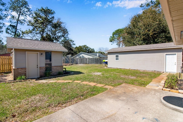 view of yard featuring an outbuilding, a patio, and fence