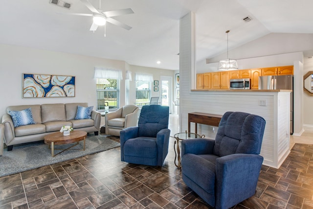 living area featuring visible vents, stone finish floor, a ceiling fan, and vaulted ceiling