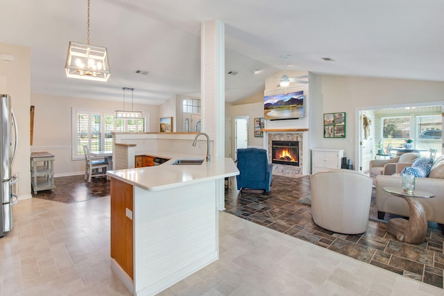 kitchen featuring open floor plan, a fireplace, freestanding refrigerator, and a sink