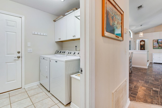 washroom with visible vents, cabinet space, baseboards, and separate washer and dryer