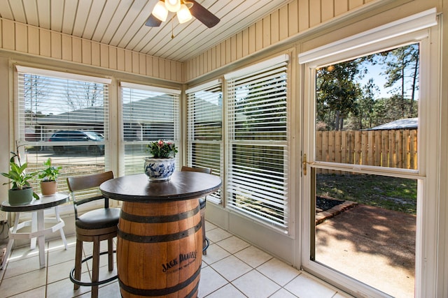 sunroom / solarium with wood ceiling and a ceiling fan