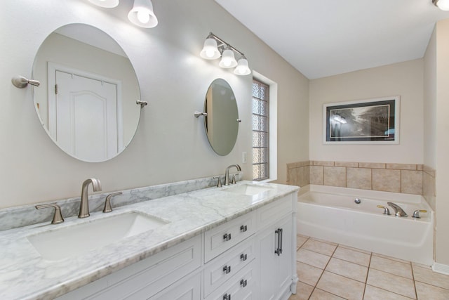 bathroom with a sink, double vanity, a bath, and tile patterned floors