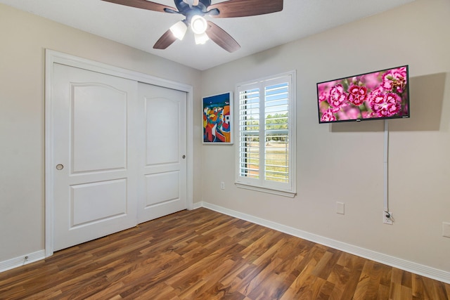 unfurnished bedroom with a closet, a ceiling fan, baseboards, and wood finished floors