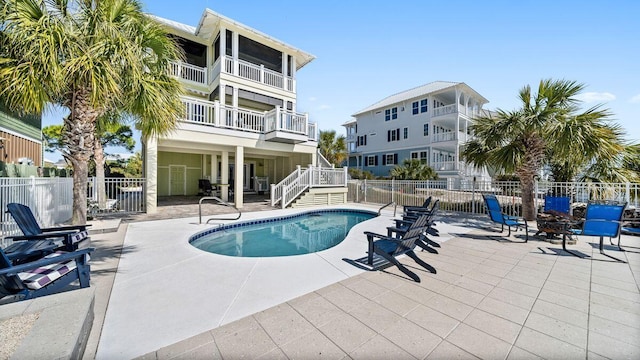 pool featuring stairway, a patio area, and fence