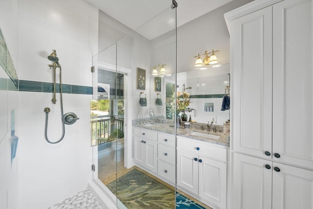 bathroom featuring double vanity, a shower stall, and a sink