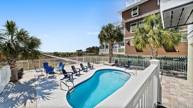 community pool featuring a patio and fence