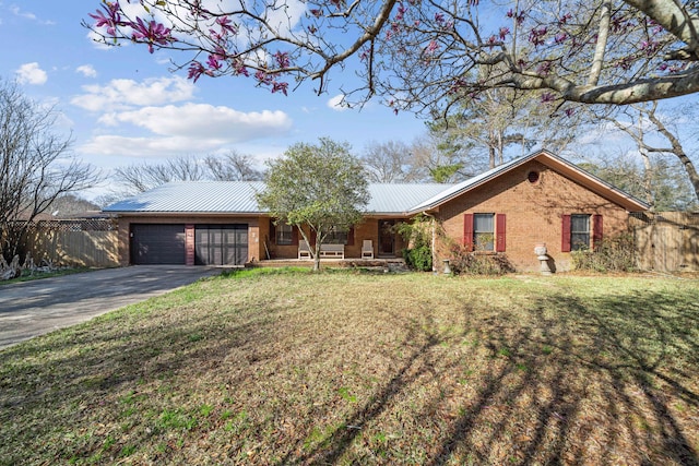 ranch-style home with brick siding, a front lawn, aphalt driveway, metal roof, and an attached garage