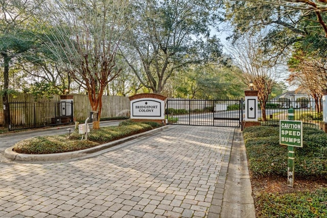 exterior space with a gate, curbs, and a gated entry