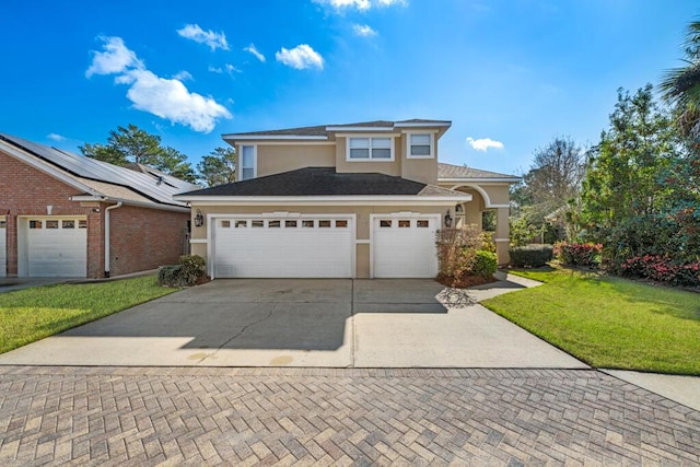 view of front of house featuring a front yard, an attached garage, driveway, and stucco siding