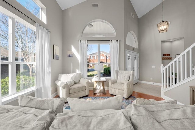 living area with stairway, plenty of natural light, and visible vents