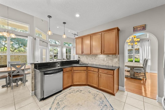 kitchen featuring a sink, arched walkways, a notable chandelier, and dishwasher