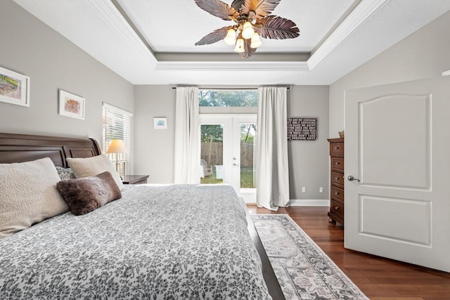 bedroom with a raised ceiling, dark wood-type flooring, ornamental molding, and access to outside