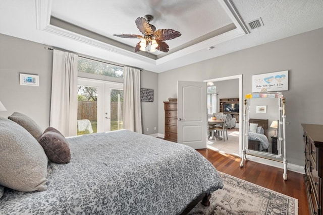 bedroom featuring visible vents, dark wood-style flooring, access to exterior, french doors, and a raised ceiling