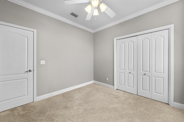 unfurnished bedroom featuring visible vents, ornamental molding, baseboards, and carpet floors