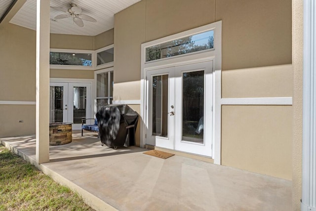 view of exterior entry featuring french doors, a ceiling fan, and stucco siding