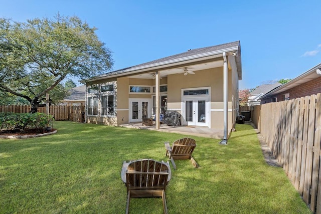 back of property with a ceiling fan, french doors, a fenced backyard, and stucco siding