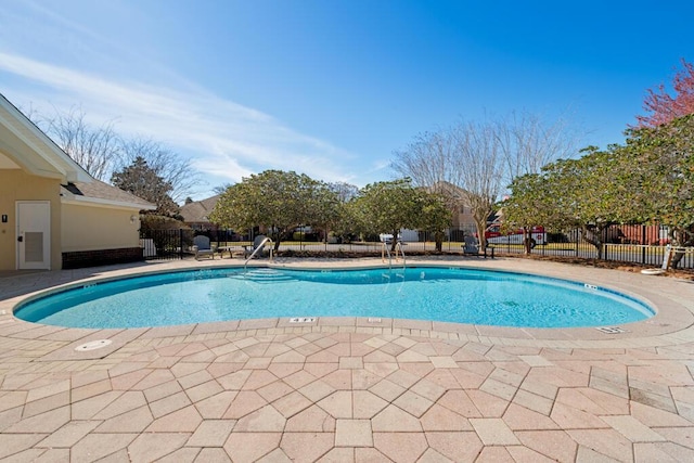 community pool featuring a patio and fence