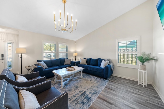 living room with an inviting chandelier, wood finished floors, baseboards, and high vaulted ceiling