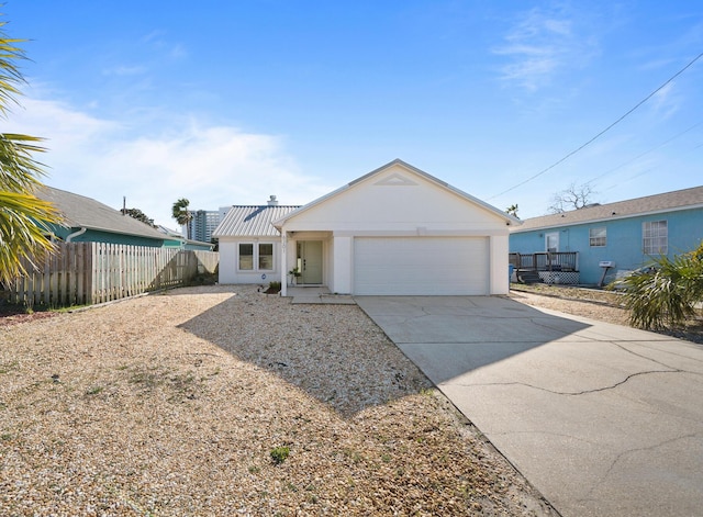 view of front of home featuring a garage, concrete driveway, stucco siding, and fence