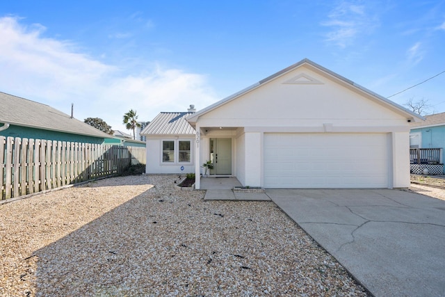 ranch-style house with fence, concrete driveway, stucco siding, metal roof, and a garage