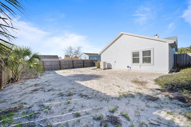 exterior space with central AC unit, a fenced backyard, and stucco siding