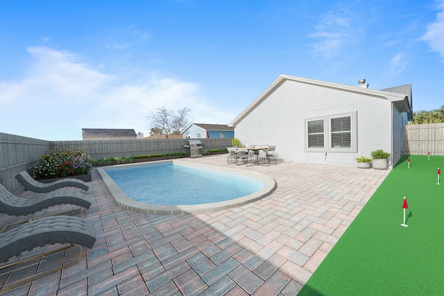 view of swimming pool featuring outdoor dining area, a patio area, a fenced backyard, and grilling area