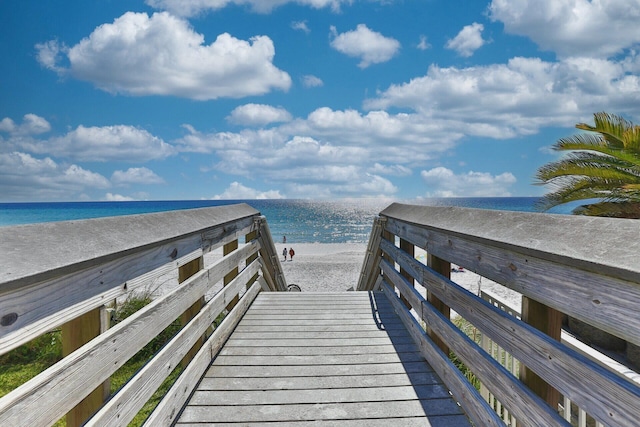 view of community featuring a water view and a beach view