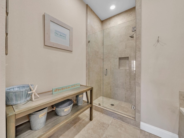 full bathroom with baseboards and a shower stall