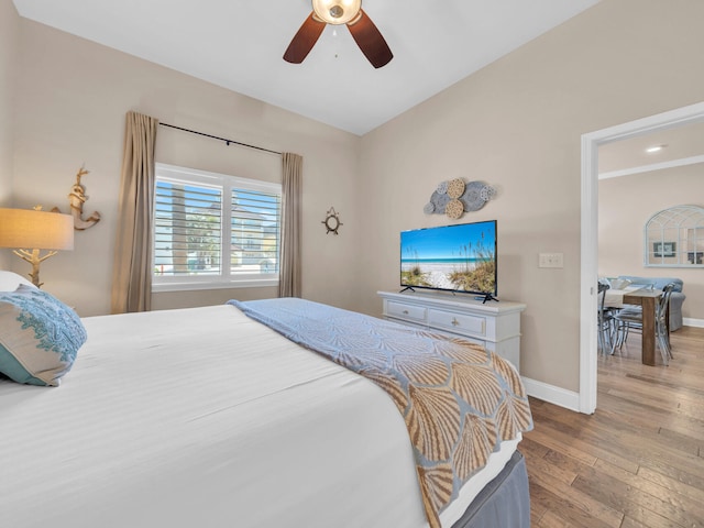 bedroom featuring ceiling fan, baseboards, and wood finished floors