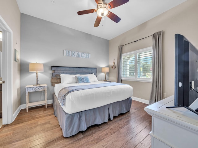 bedroom featuring baseboards, light wood-style floors, and ceiling fan