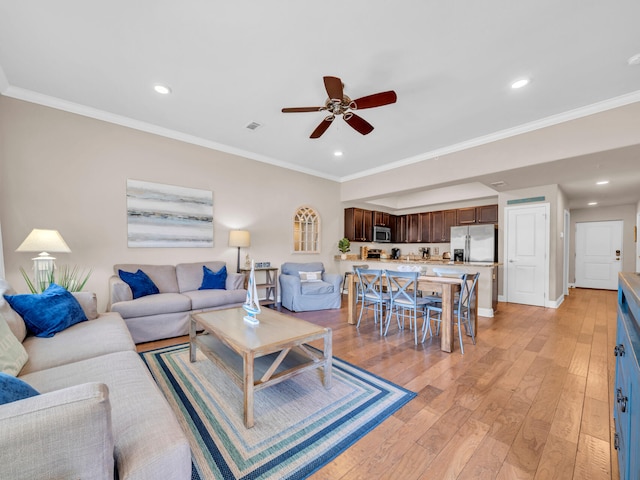 living room featuring light wood finished floors, recessed lighting, crown molding, and a ceiling fan