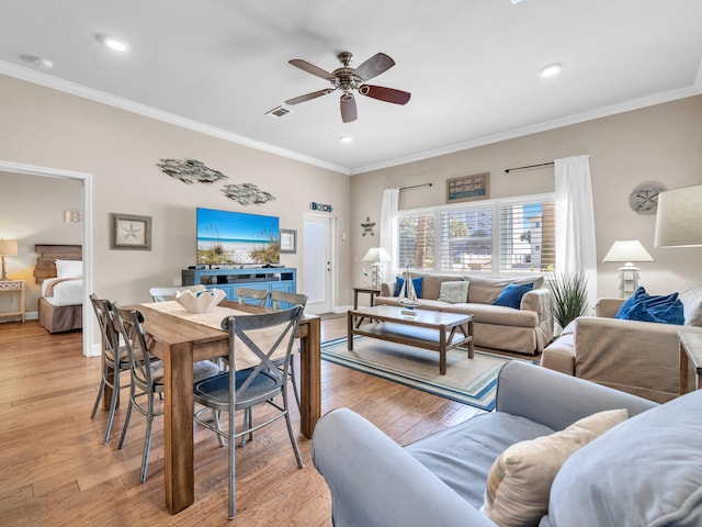 living room featuring baseboards, crown molding, light wood-style floors, and a ceiling fan