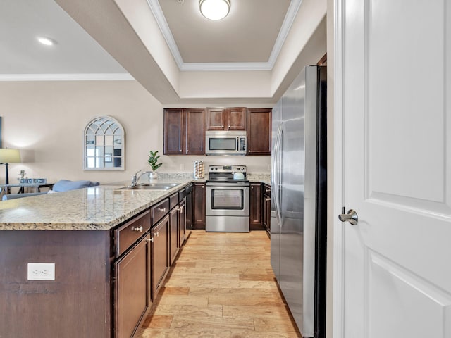 kitchen featuring ornamental molding, a sink, light wood-style floors, appliances with stainless steel finishes, and dark brown cabinets